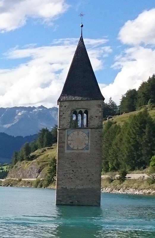 … steht das Wasser bis zum Hals. Glockenturm der alten Pfarrkirche St. Katharina im Reschensee, Südtirol (c) Von Noclador – Eigenes Werk, CC BY-SA 4.0, https://commons.wikimedia.org/w/index.php?curid=51398010