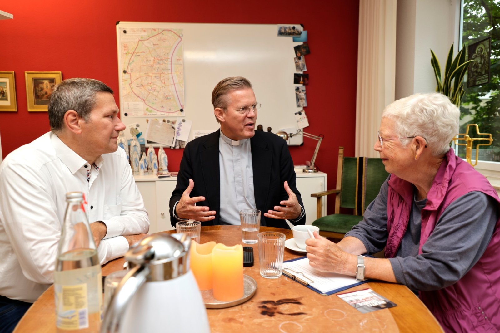 Ingrid Rasch (r) und Michael Wissen (l) von der Pfarrbriefredaktion im Gespräch mit Pfarrer Dominik Meiering (c) SilviaBins